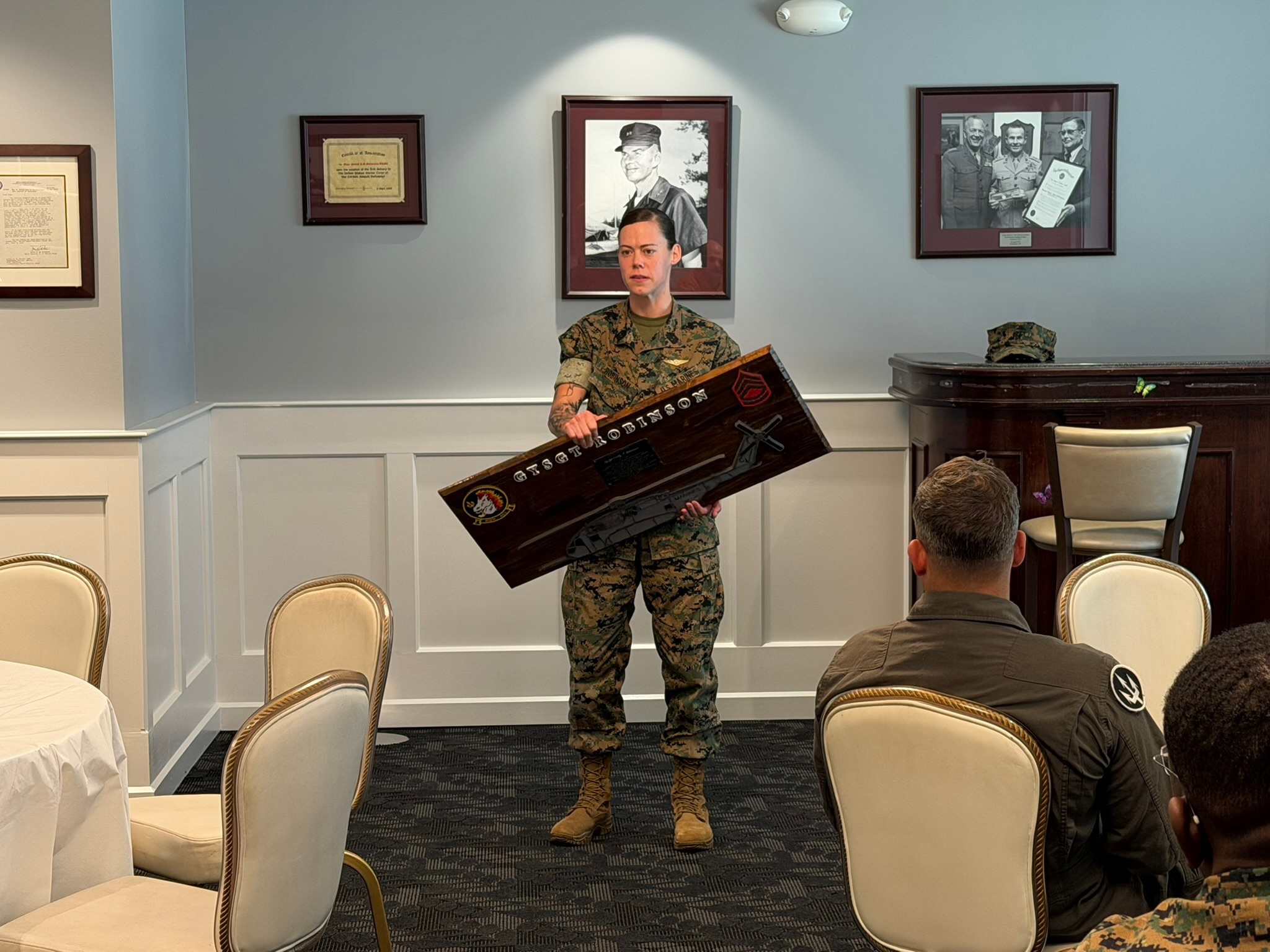 Marine standing with a custom plaque during a ceremony