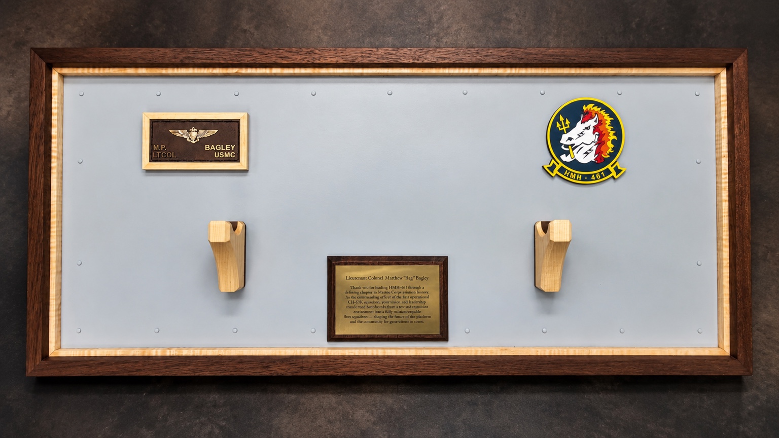 Studio view of a framed HMH-461 command display with sword mounts, squadron insignia and engraved dedication plates